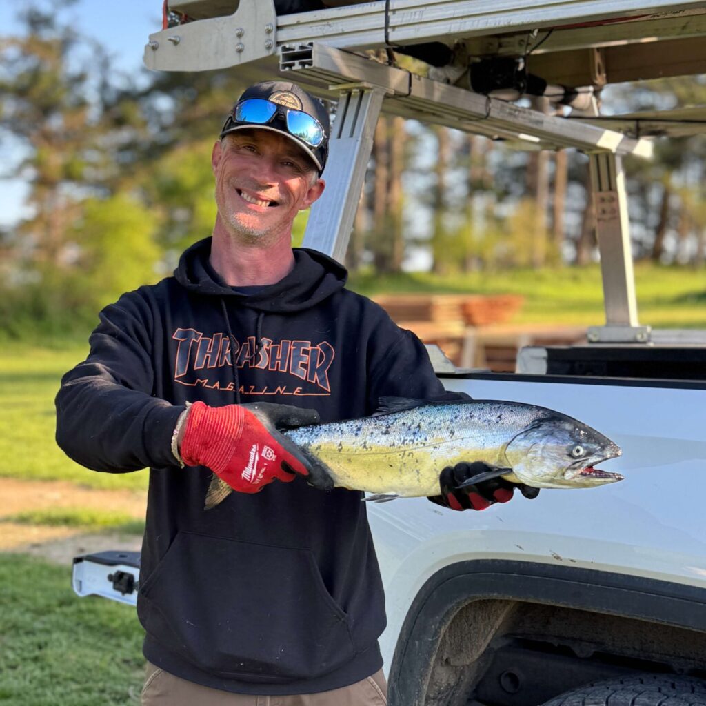 Captain smiling proudly with a big catch in hand after returning from a successful guided fishing charter tour.