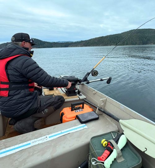 Captain on a fishing charter tour, casting a rod from the side of the boat as part of the guided ocean tour experience.